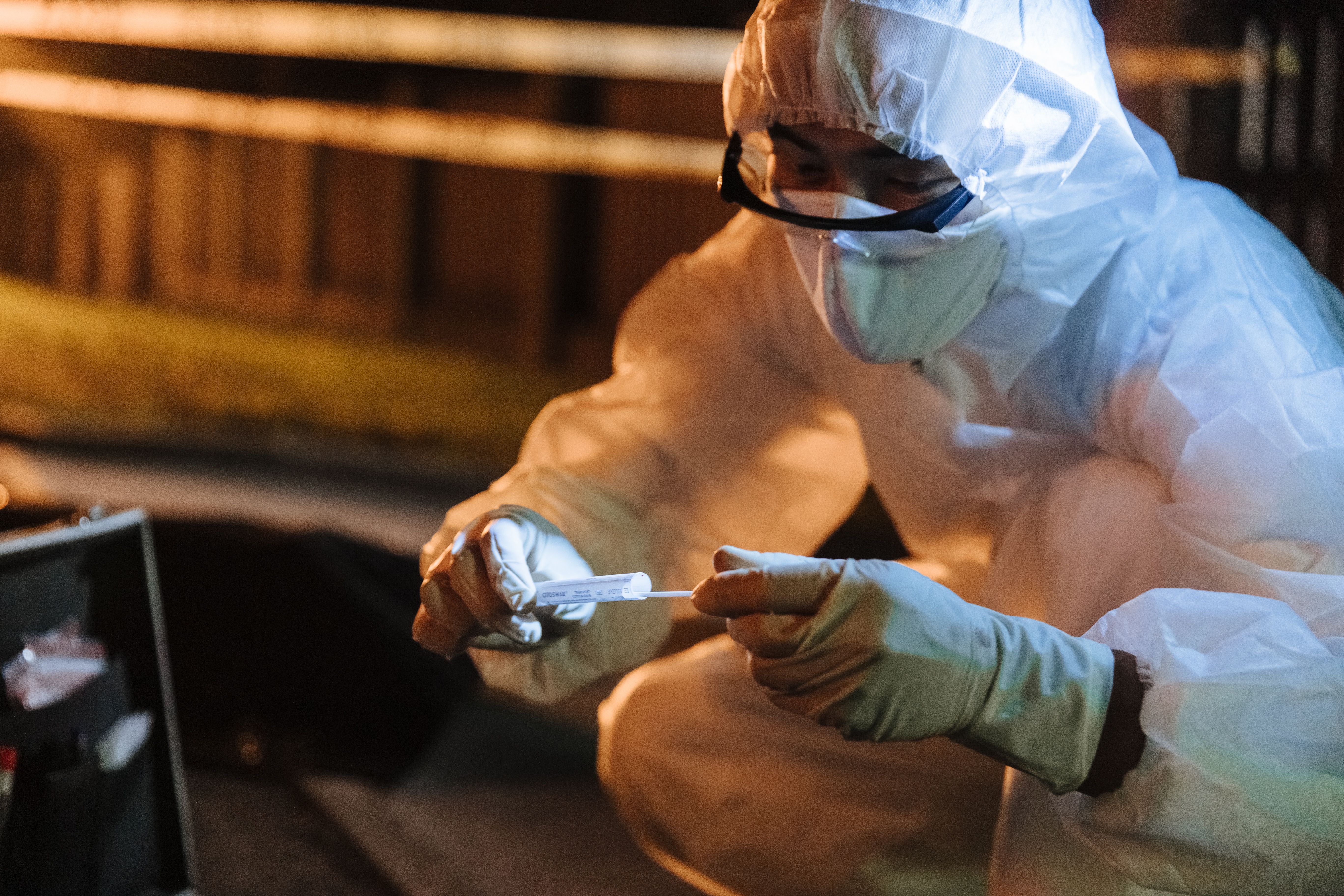 Forensic investigator in protective gear collecting evidence at night, representing digital evidence verification